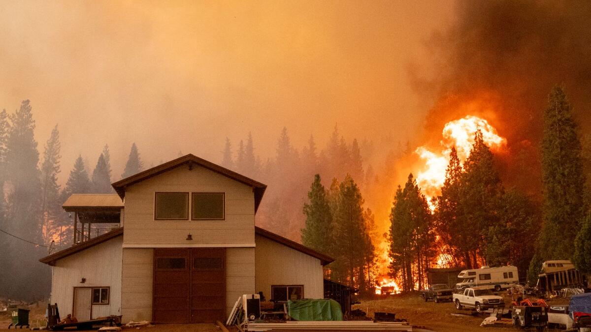 Flames approach a home as the Dixie fire moves into Greenville, California. Photo: AFP