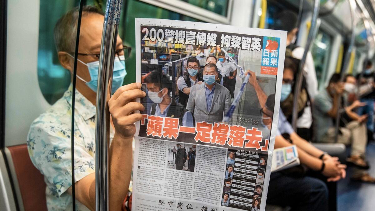 A commuter reads a copy of the Apple Daily newspaper on a train in Hong Kong, a day after authorities conducted a search of the newspaper's headquarters after the company’s founder Jimmy Lai was arrested under the new national security law. Hong Kong pro-democracy media tycoon Jimmy Lai was arrested on August 10 and led in handcuffs through his newspaper office as police raided the building, part of a sweeping crackdown on dissent since China imposed a security law on the city. Photo: AFP