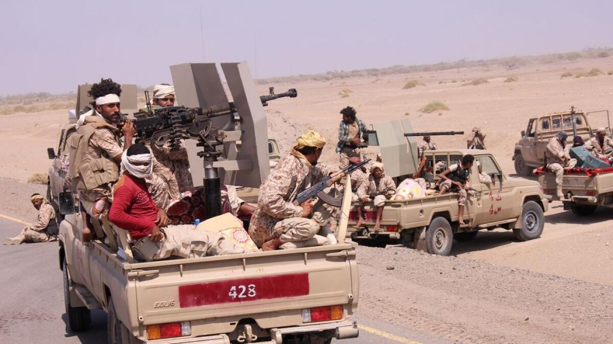 Members of the Yemeni army ride on the back of military trucks near the city of Al Mokha, Yemen. 