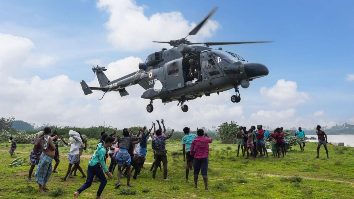 Flood-affected people receive relief material from the Indian Navy personnel at a flood-hit area of Tamil Nadu. Photo: PTI