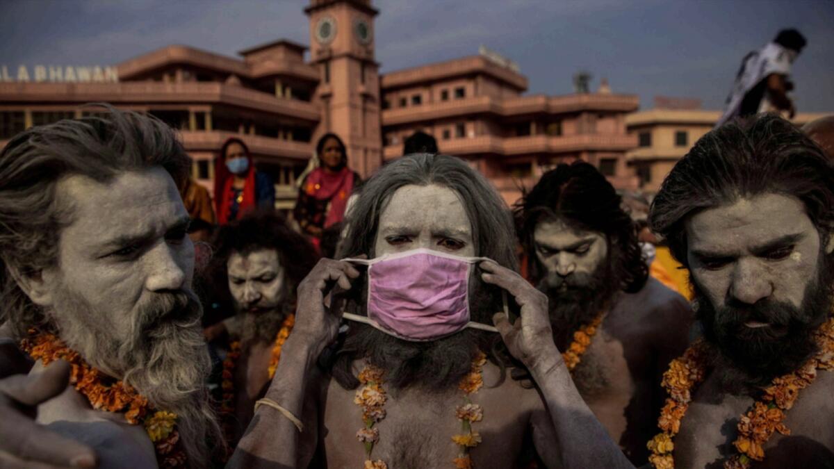 This photo by Danish Siddiqui shows a 'Naga Sadhu,' or Hindu holy man, placing a mask across his face before entering the Ganges river during the traditional Shahi Snan, at the Kumbh Mela festival in Haridwar, India.  —AP