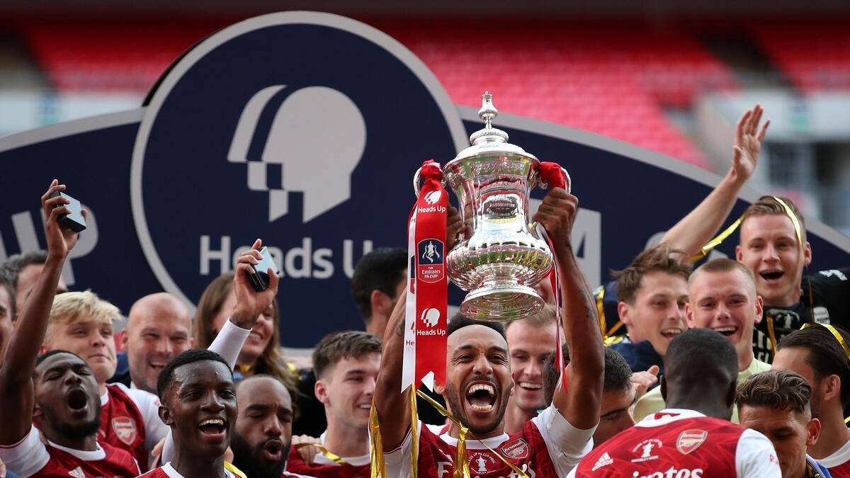 Arsenal's Gabonese striker Pierre-Emerick Aubameyang holds the winners' trophy as the team celebrate victory after the FA Cup final against Chelsea. (AFP)