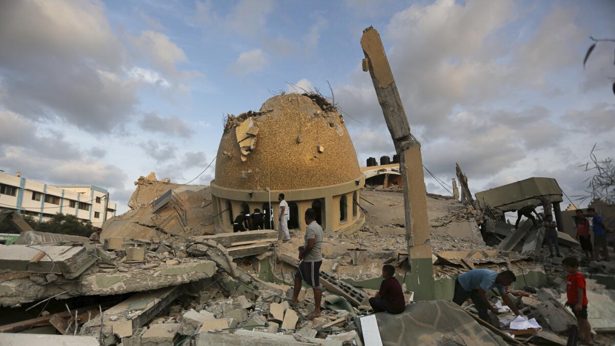 People stand outside a mosque destroyed in an Israeli air strike in Khan Younis, Gaza Strip. — AP