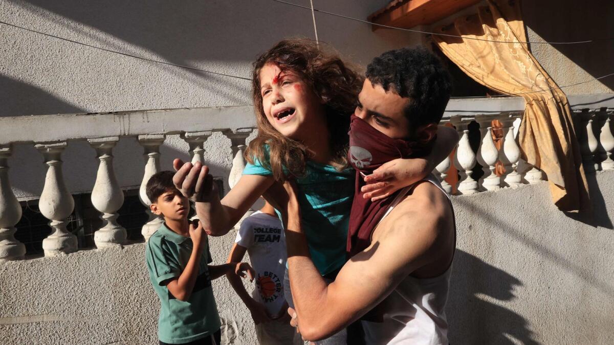 A man carries a rescued Palestinian girl from the rubble of a building after an Israeli airstrike at the Rafah refugee camp. — AFP file photo