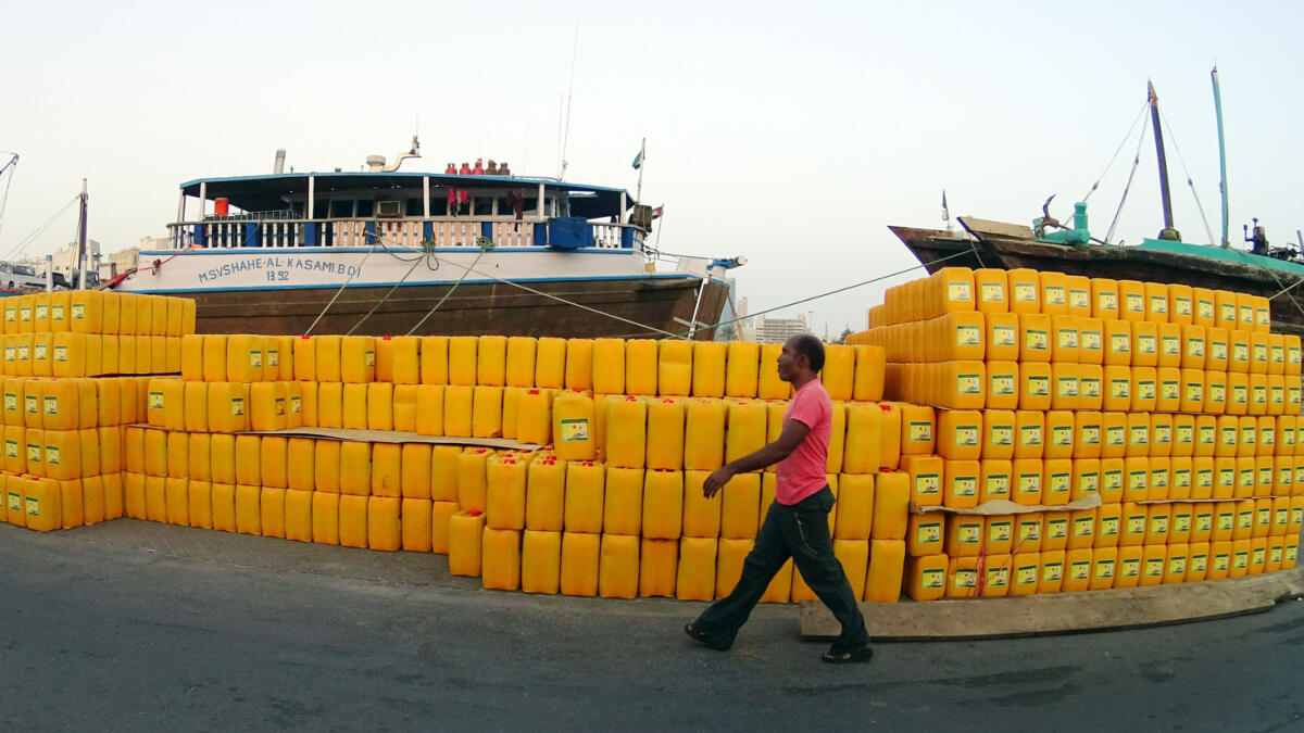 A man is passing by the oil containers stock that is ready for export at port Khalid in Sharjah.- Photo by M.Sajjad/ Khaleej Times