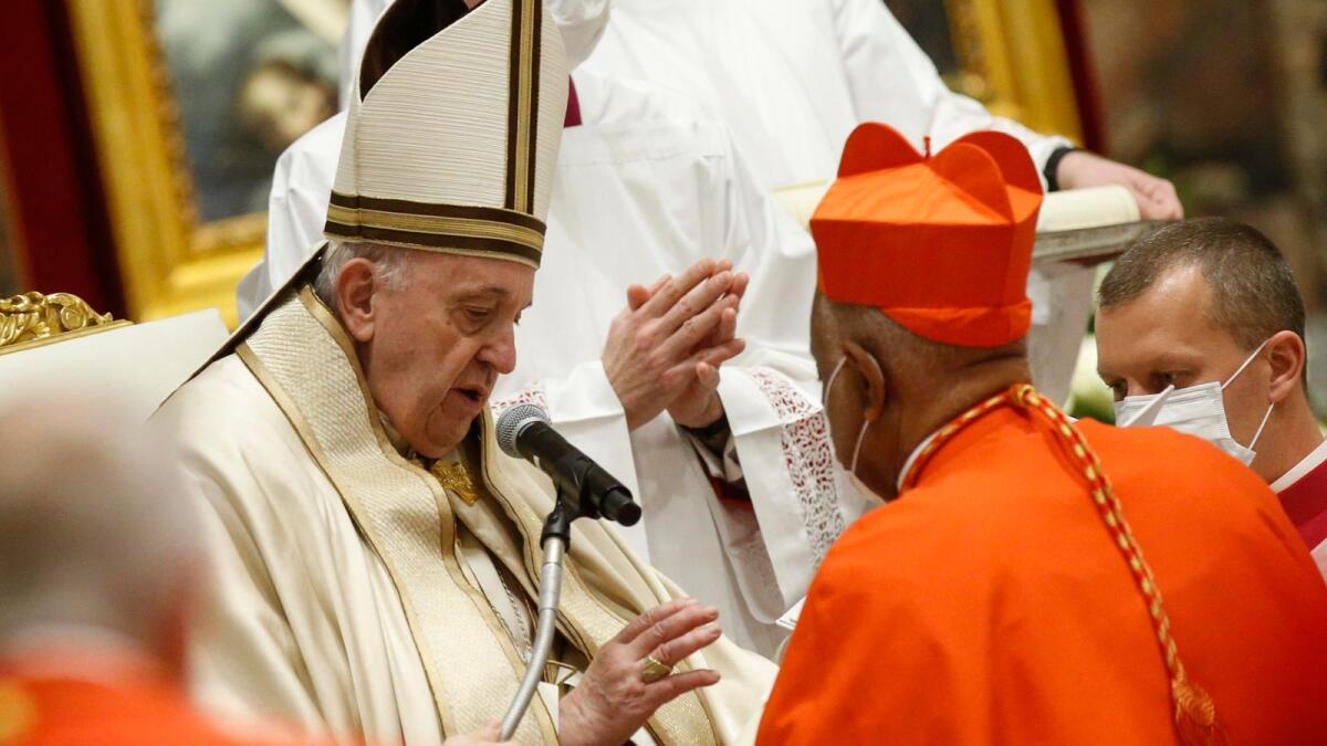 US Archbishop Wilton Gregory of Washington (R) receives his biretta from Pope Francis as he is created Cardinal during a consistory to create 13 new cardinals, on Saturday at St. Peter's Basilica in The Vatican.