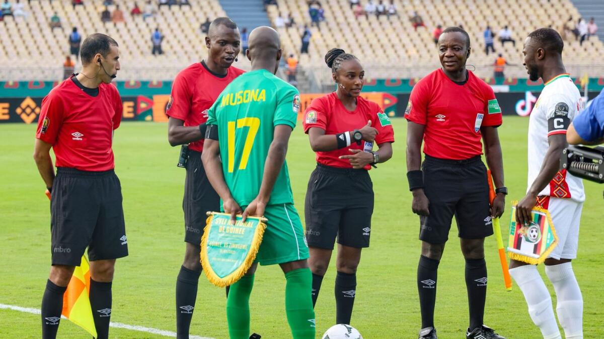 Rwandan referee Salima Mukansanga (third from right) proposes the toss choice to Guinea's Naby Keita (right). — AFP