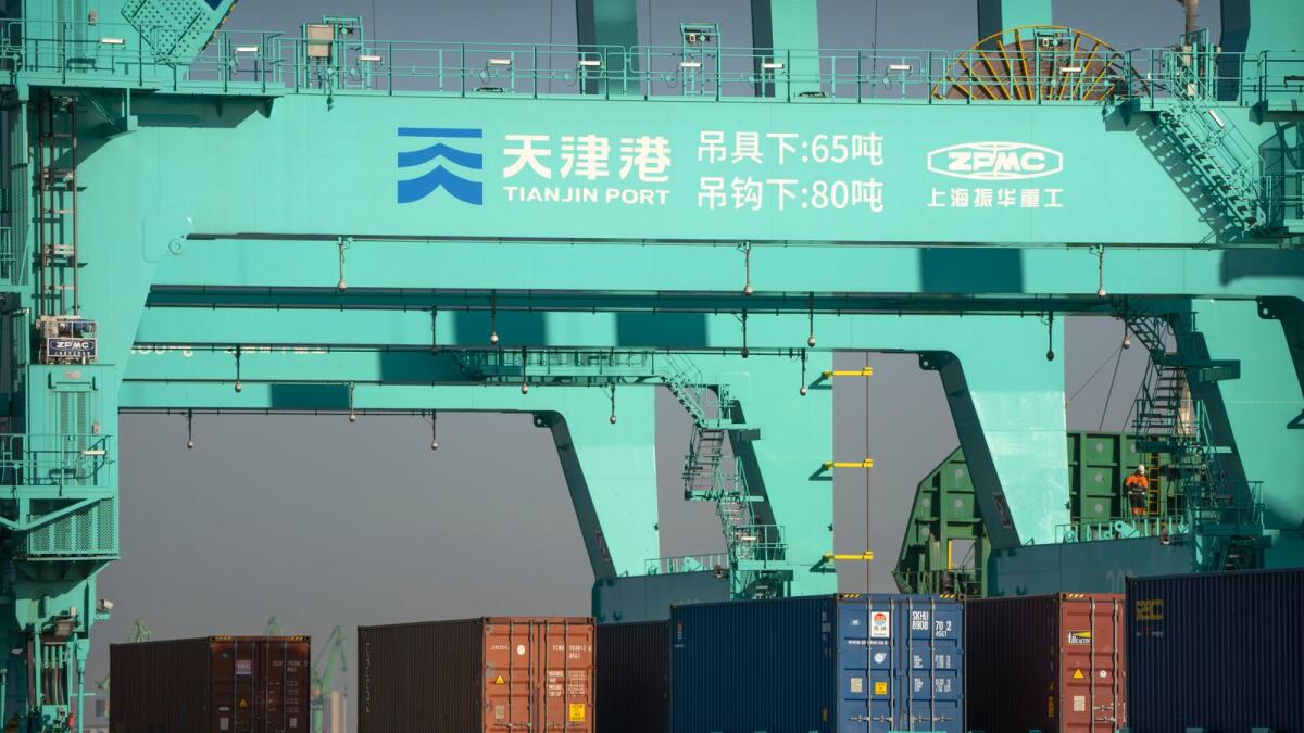 Unmanned trucks move shipping containers at an automated container port in Tianjin, China. China's economic growth fell to three per cent last year under pressure from antivirus controls and a real estate slump but is gradually reviving after restrictions that kept millions of people at home were lifted. — AP