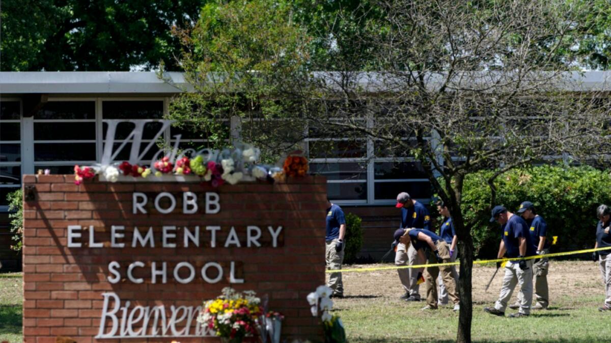 Investigators search for evidence outside Robb Elementary School in Uvalde. — AP file