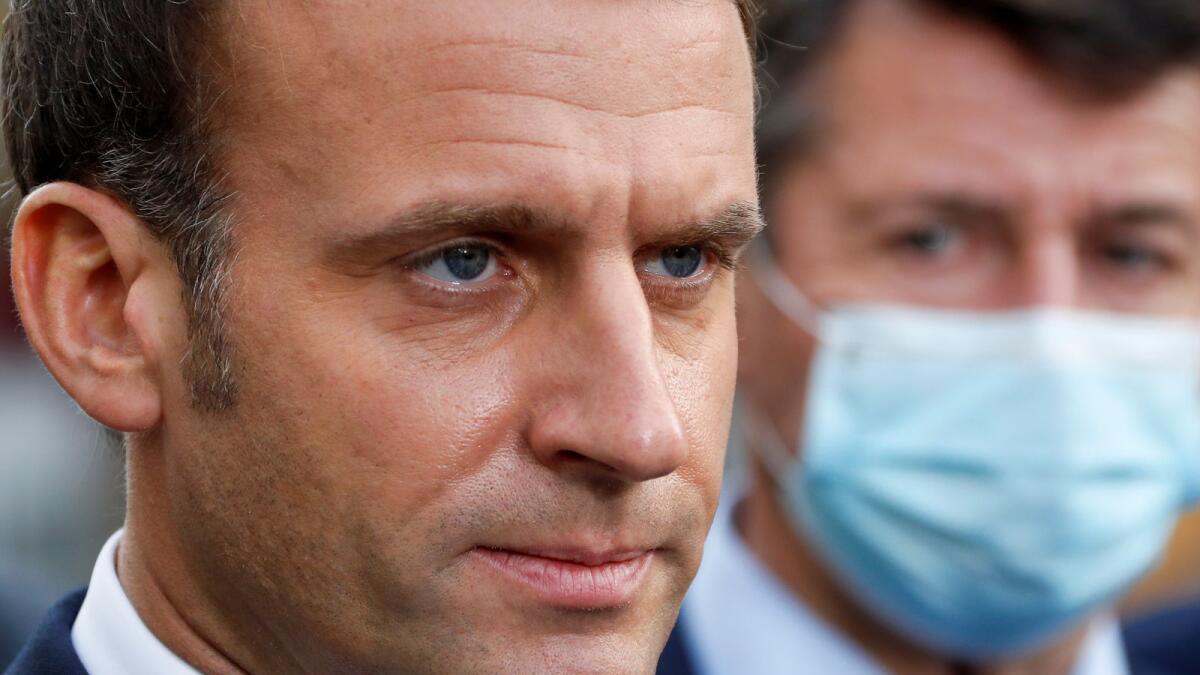 French President Emmanuel Macron looks on as he speaks to the media during the visit to the scene of a knife attack at Notre Dame church in Nice, France October 29, 2020.