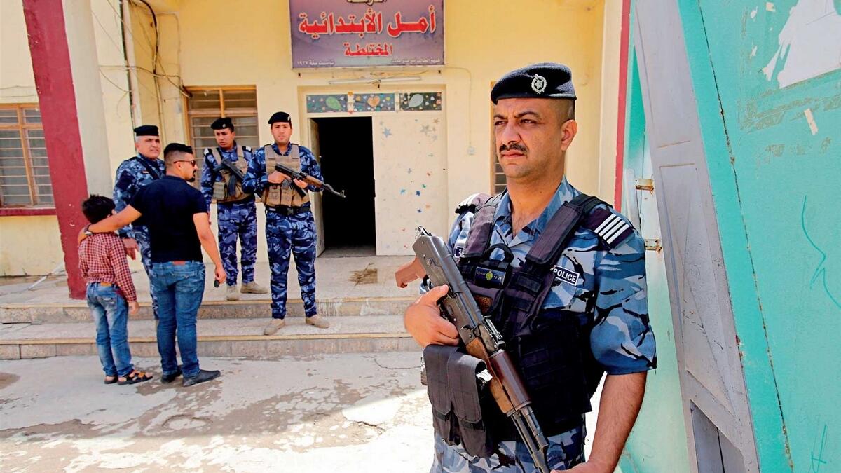 Iraqi security forces guard a polling station in Baghdad, Iraq. Voters will cast their ballots today in the first parliamentary election since the country declared victory over the  Daesh group. — AP