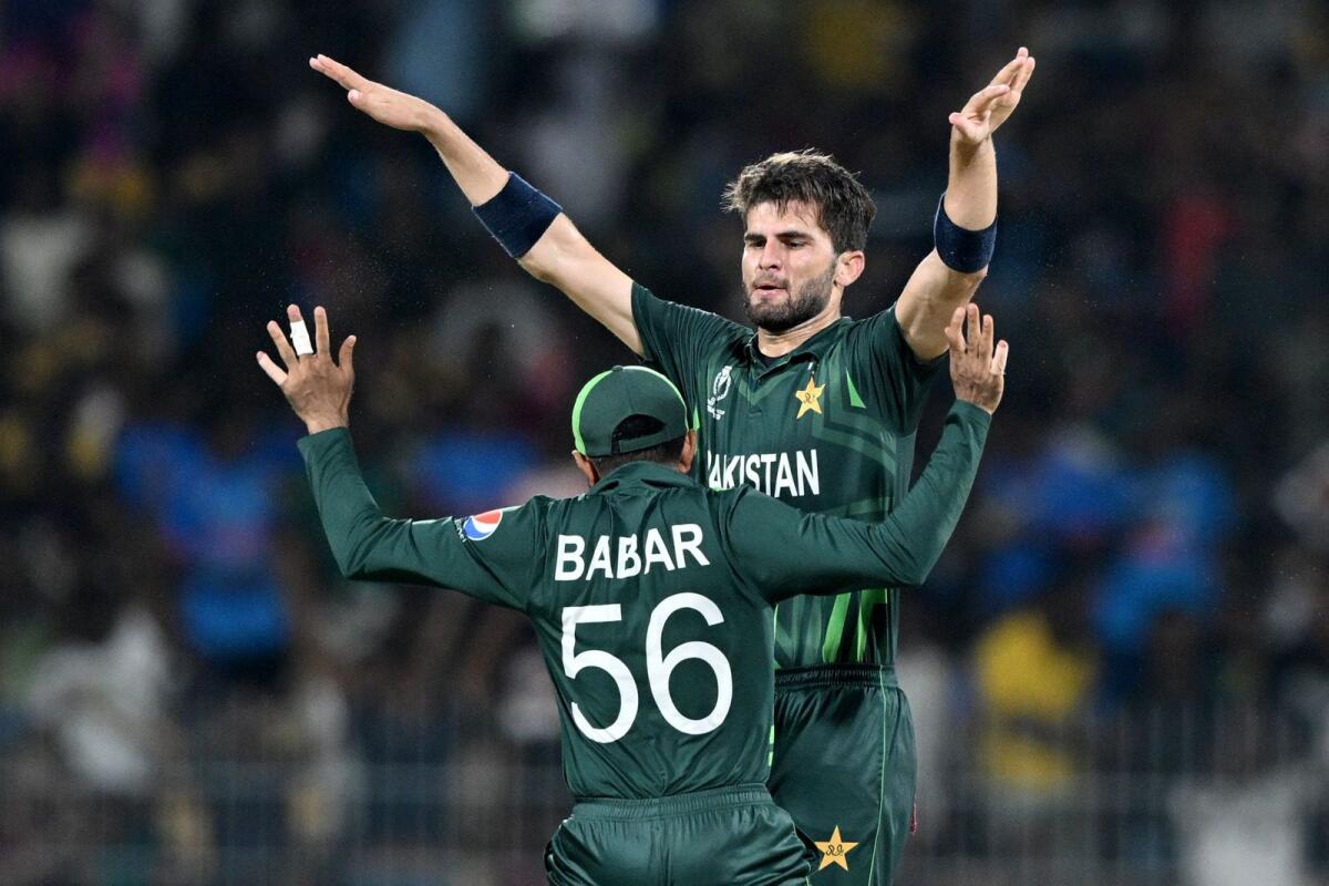 Pakistan's Shaheen Shah Afridi (R) celebrates with captain Babar Azam after taking the wicket of South Africa's Quinton de Kock. - AFP