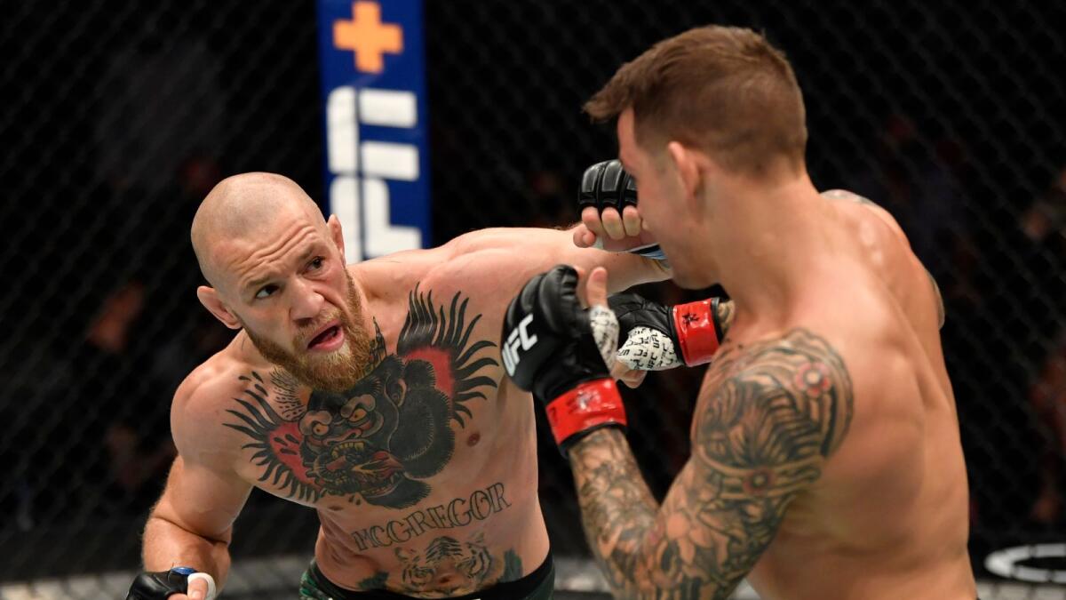Conor McGregor of Ireland punches Dustin Poirier in a lightweight fight during the UFC 257 event inside Etihad Arena on UFC Fight Island. — Reuters