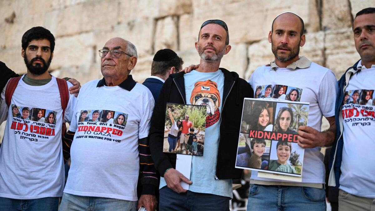 Relatives of missing Israelis hold portraits of their loved ones in front of the Western Wall while attending a day of prayer in the Old City of Jerusalem. — AFP
