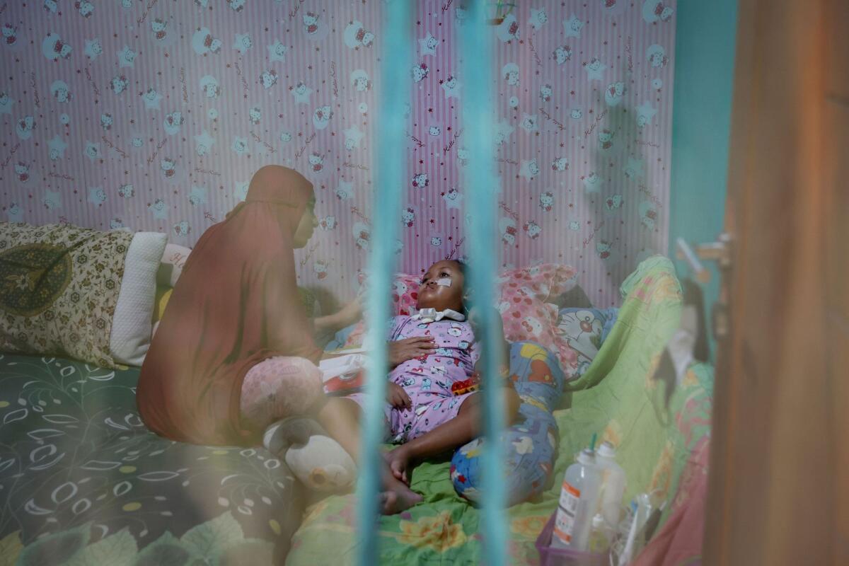 Desi Permatasari, 32, comforts her daughter, Sheena Almaera Maryam, 5, who was prescribed contaminated cough syrup last year, in their home in Bogor, West Java province, Indonesia, October 6, 2023. — Reuters file
