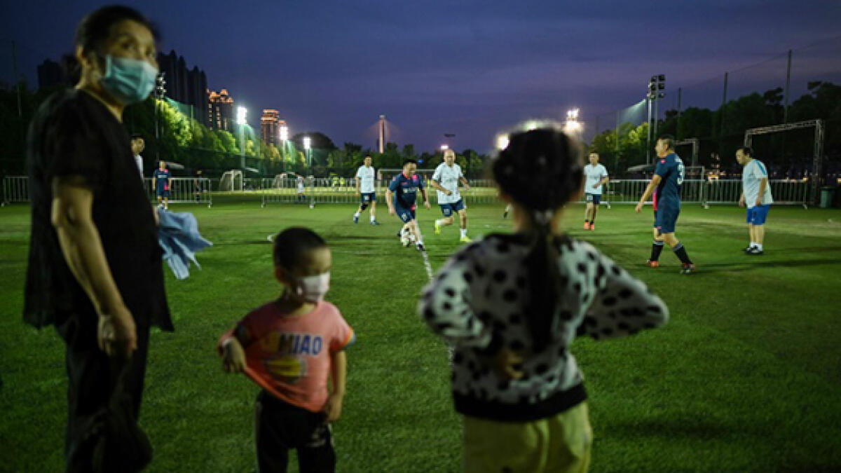 People play football in a field in Wuhan, in China's central Hubei province after coronavirus restrictions were eased. -- AFP