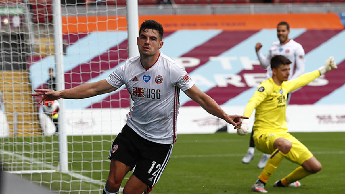Sheffield United's John Egan celebrates scoring the equaliser against Burnley during the English Premier League match at Turf Moor in Burnley, north west England on Sunday. -- AFP