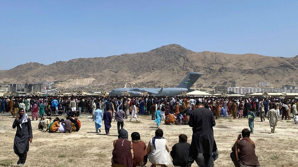 Hundreds of people gather near a US Air Force C-17 transport plane at the perimeter of the international airport in Kabul, Afghanistan, Aug. 16, 2021. An Afghan couple who arrived in the US as refugees are suing a US Marine and his wife for allegedly abducting their baby. — AP file
