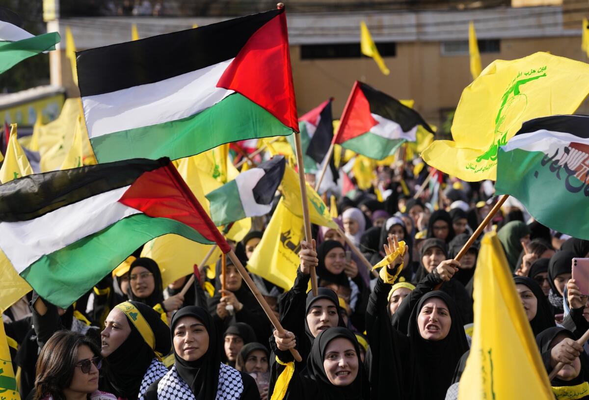 Supporters of Hezbollah group shout slogans and wave Palestinian and their group flags. Photo: AP