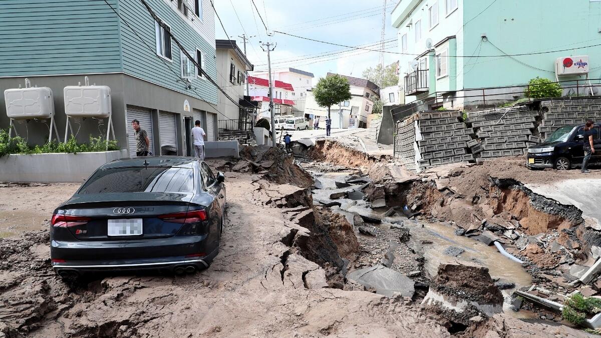 A car is seen stuck on a road damaged by an earthquake in Sapporo, Hokkaido prefecture.- AFP