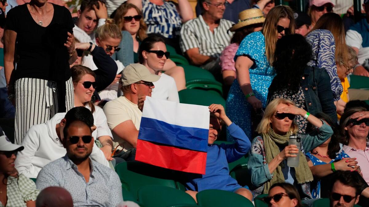 A spectator holding a Russian flag watches the men's singles third round match between Russia's Daniil Medvedev and Croatia's Marin Cilic last year. — AP