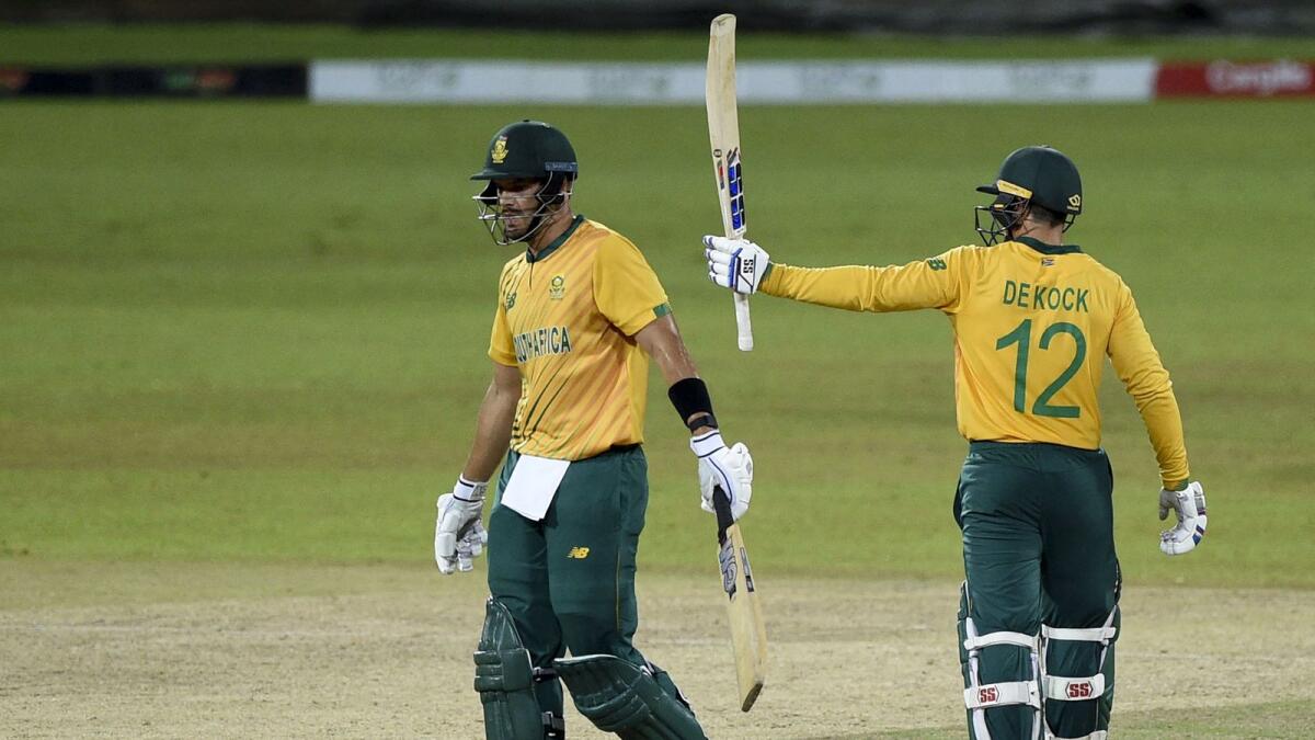 South Africa's Quinton de Kock celebrates after scoring a half-century (50 runs) as teammate Aiden Markram looks on. — AFP