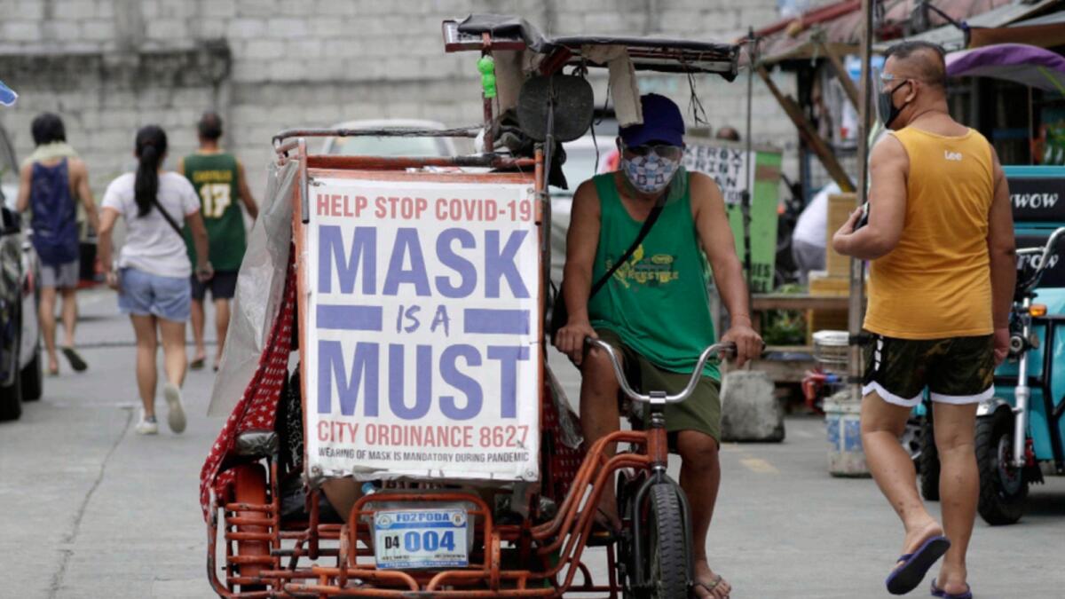 A man rides his pedicab with a slogan to remind people to wear masks to prevent the spread of the coronavirus in Manila. — AP