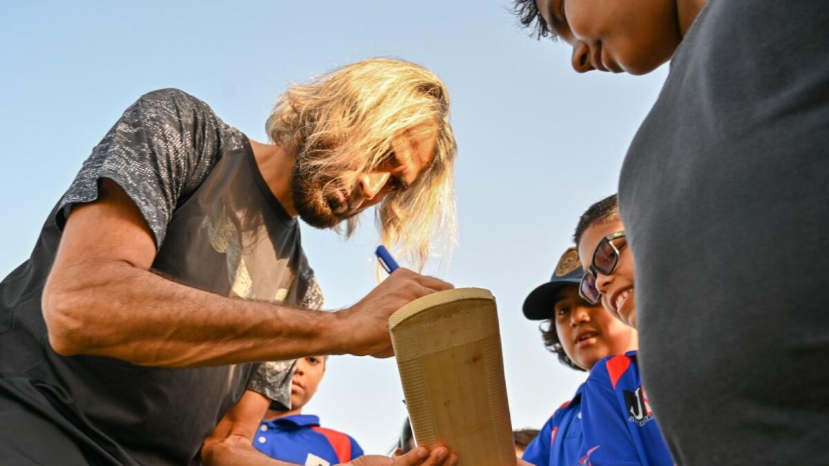 South African leg-spinner Imran Tahir signing an autograph for a G Force Cricket Academy youngster in Dubai. (Photo by M. Sajjad)