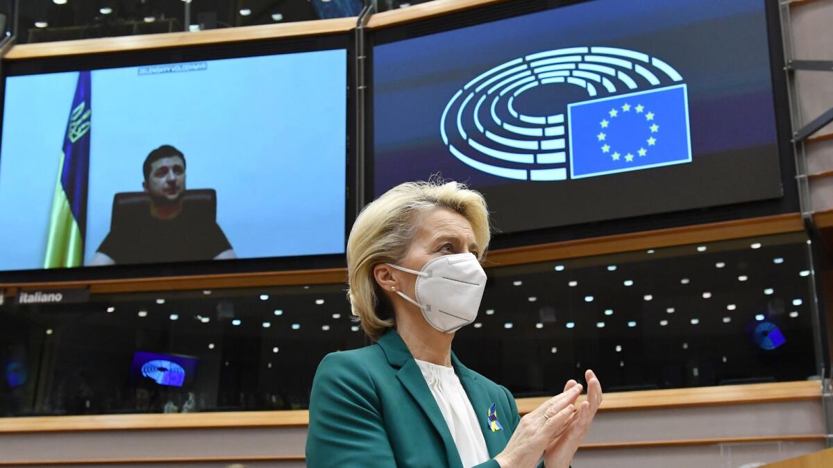 European Commission President Ursula von der Leyen (C) applauds Ukrainian President Volodymyr Zelensky (L) who appears on a screen as he speaks in a video conference during a special plenary session of the European Parliament focused on the Russian attack of Ukraine at the EU headquarters in Brussels, on March 01, 2022. Photo: AFP