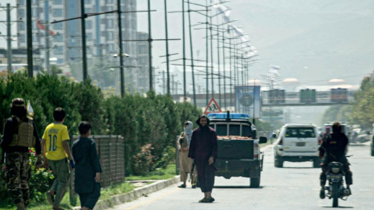 Taliban fighters (C) stand guard along a road near the Russian embassy after a suicide attack in Kabul. — AFP