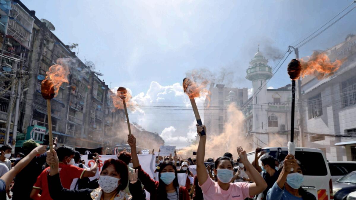 A group of women hold torches as they protest against the military coup in Yangon. — Reuters file