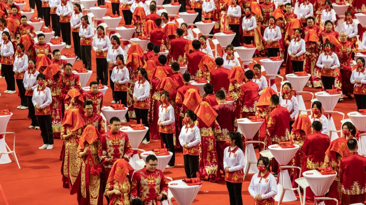 A mass wedding to encourage residents to resist “bad habits,” such as high “bride prices,” payments that grooms make to their prospective wives’ families, in Nanchang, China, March 8, 2023. Grooms are now paying more money for wives, in a tradition that has faced growing resistance. (Qilai Shen/The New York Times)