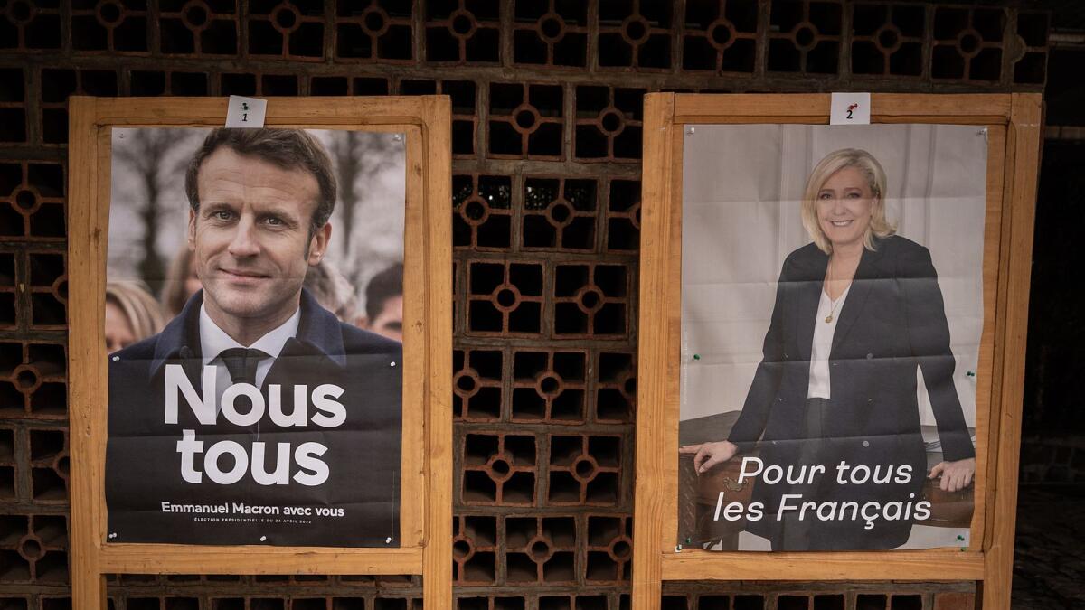 Posters of French President and candidate for re-election Emmanuel Macron (L) and French far-right Rassemblement National (RN) party candidate for the French presidential election Marine Le Pen (R). Photo: AFP