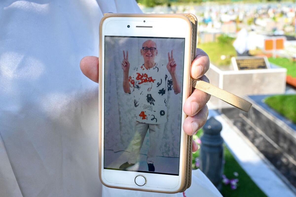 This photo taken on May 1, 2023 shows Nazira Lajim Hertslet's phone displaying an official prison 'photo shoot' image of her late brother Nazeri Lajim, who was executed for drugs trafficking, as she visits his grave at a Muslim cemetery in Singapore.-- AFP