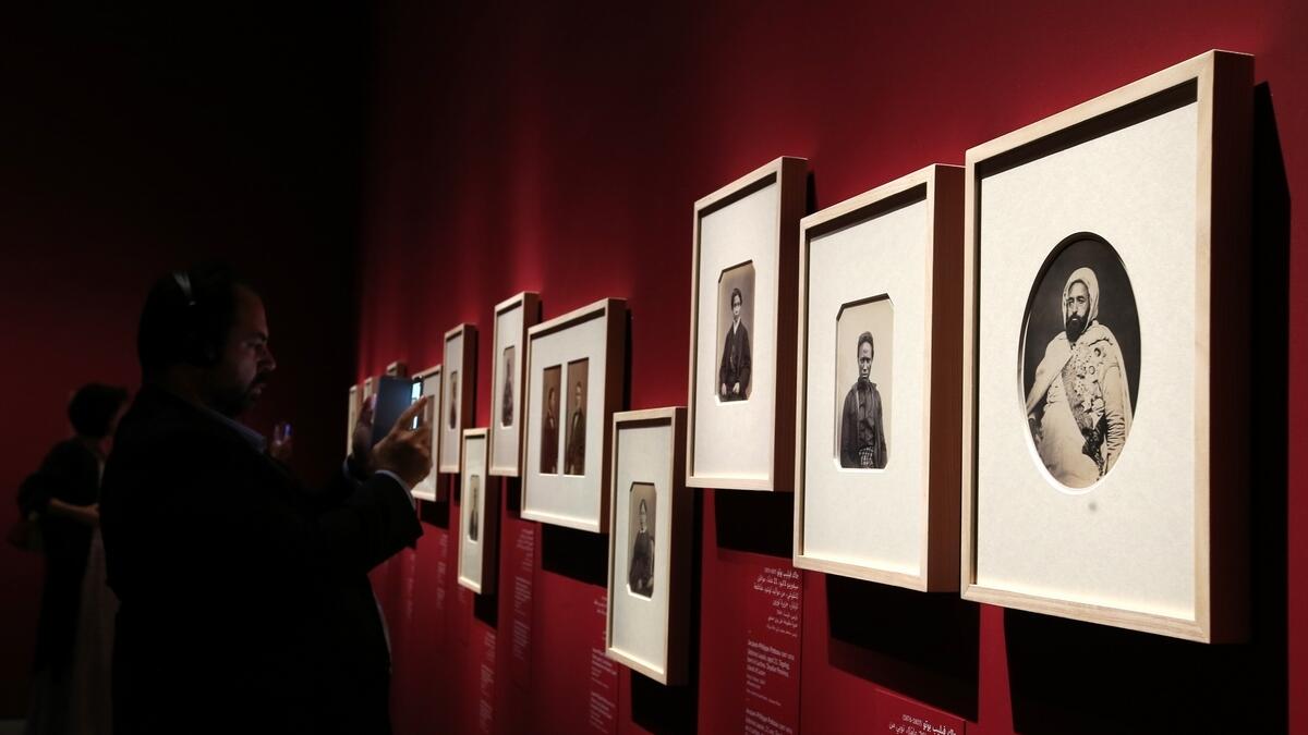 Visitors look at the selection of the worlds earliest photographs on display at the Louvre in Abu Dhabi.-Photo by Ryan Lim