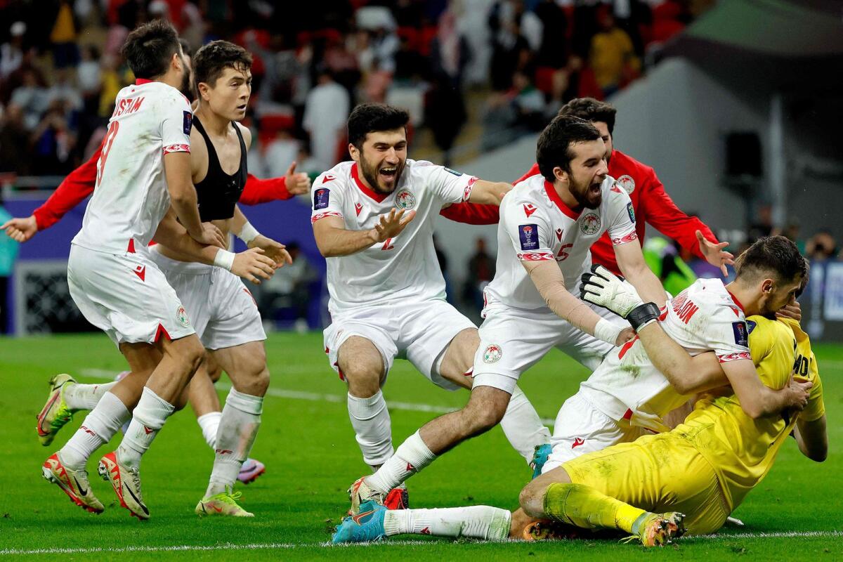 Tajikistan's players celebrate with their goalkeeper Rustam Yatimov after the penalty shoot-out. — AFP