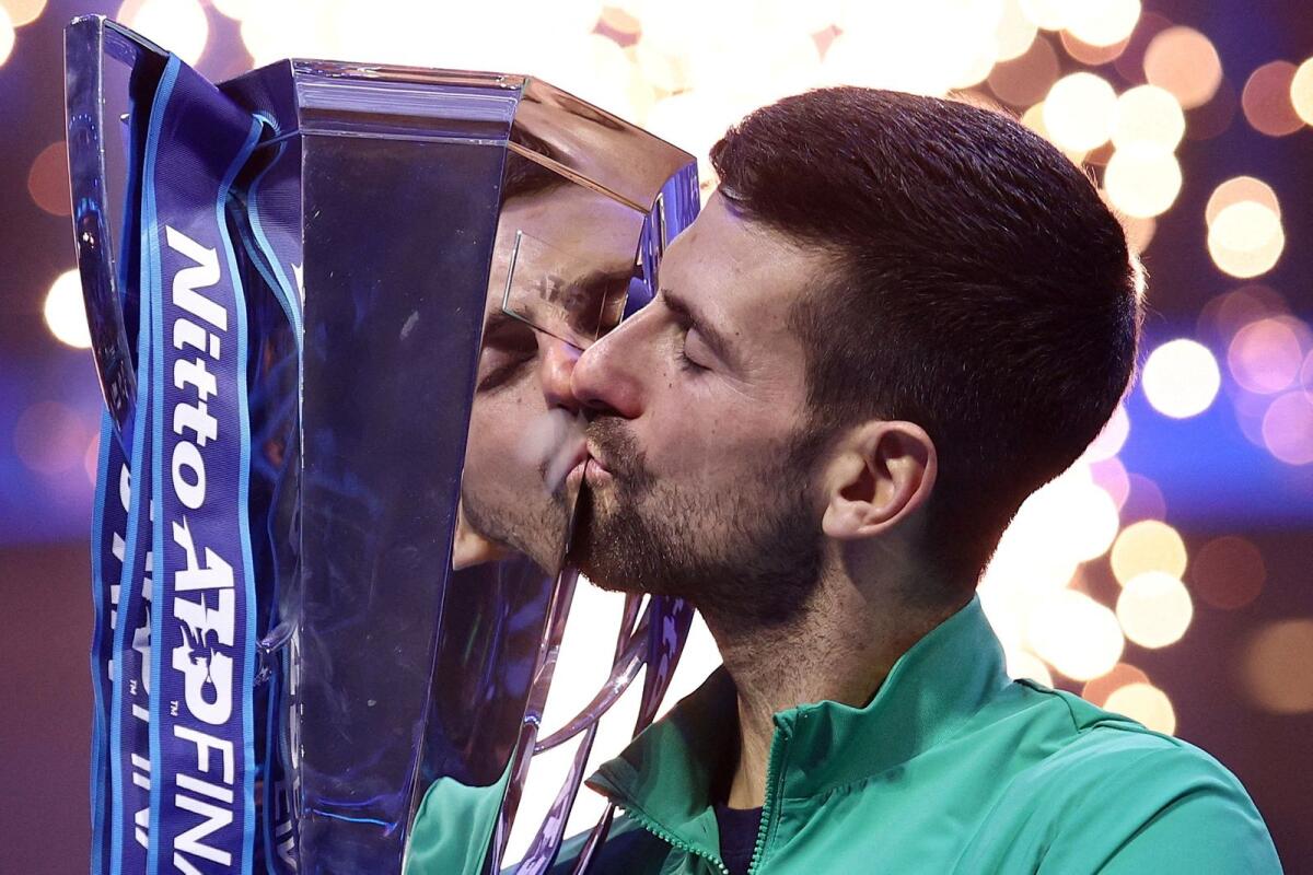 Novak Djokovic celebrates with the trophy after winning the final. — Reuters