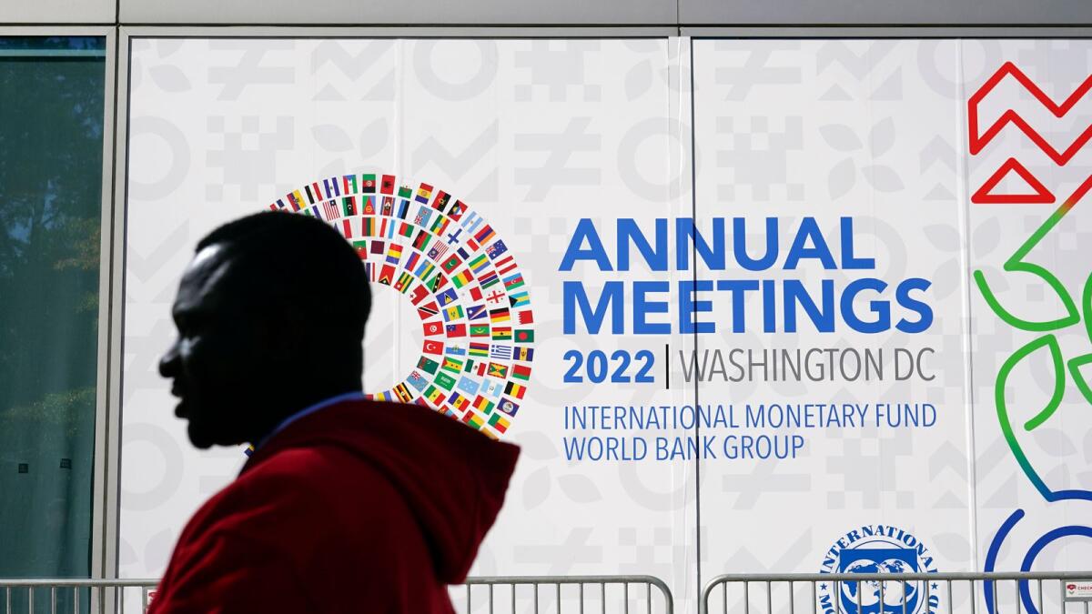 An attendee walks outside the 2022 annual meetings of the International Monetary Fund and the World Bank Group. — AP