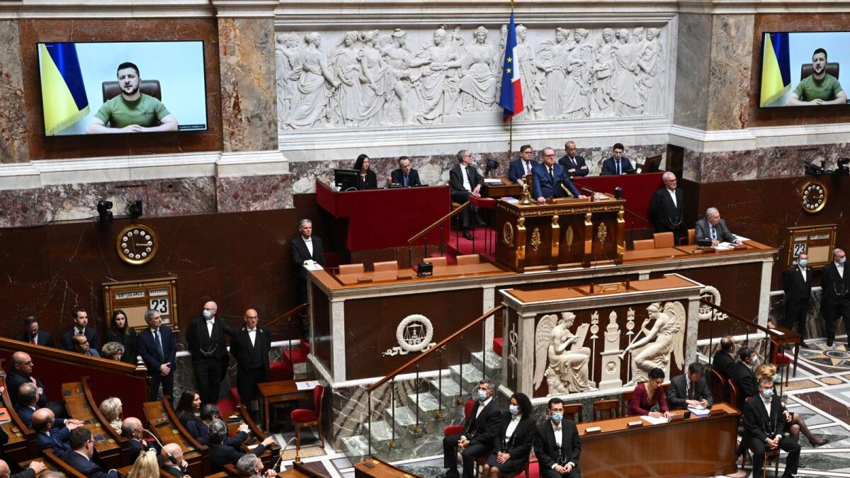 Ukrainian President Volodymyr Zelensky (on screen) delivers a speech in visioconference in front of National Assembly president Richard Ferrand (C), French deputies and senators at the Assemblee Nationale in Paris, on March 23, 2022. Photo: AFP