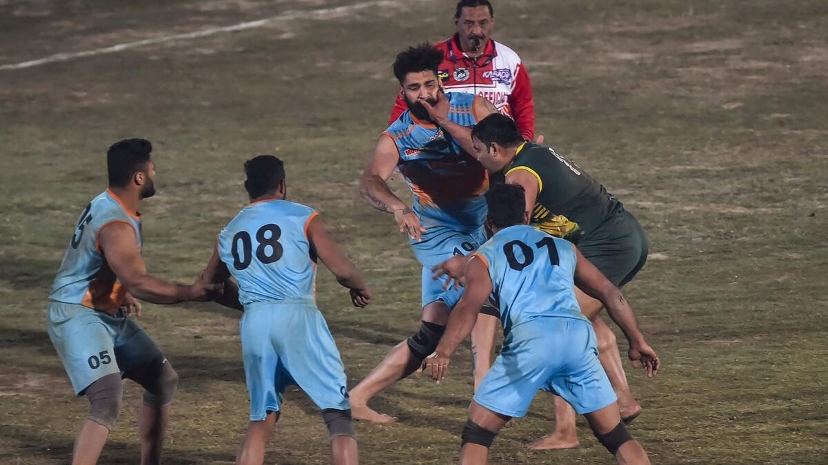 ON ATTACK: A Pakistani player (right) attempts to tag India's players during the Kabbadi World Cup in Lahore.