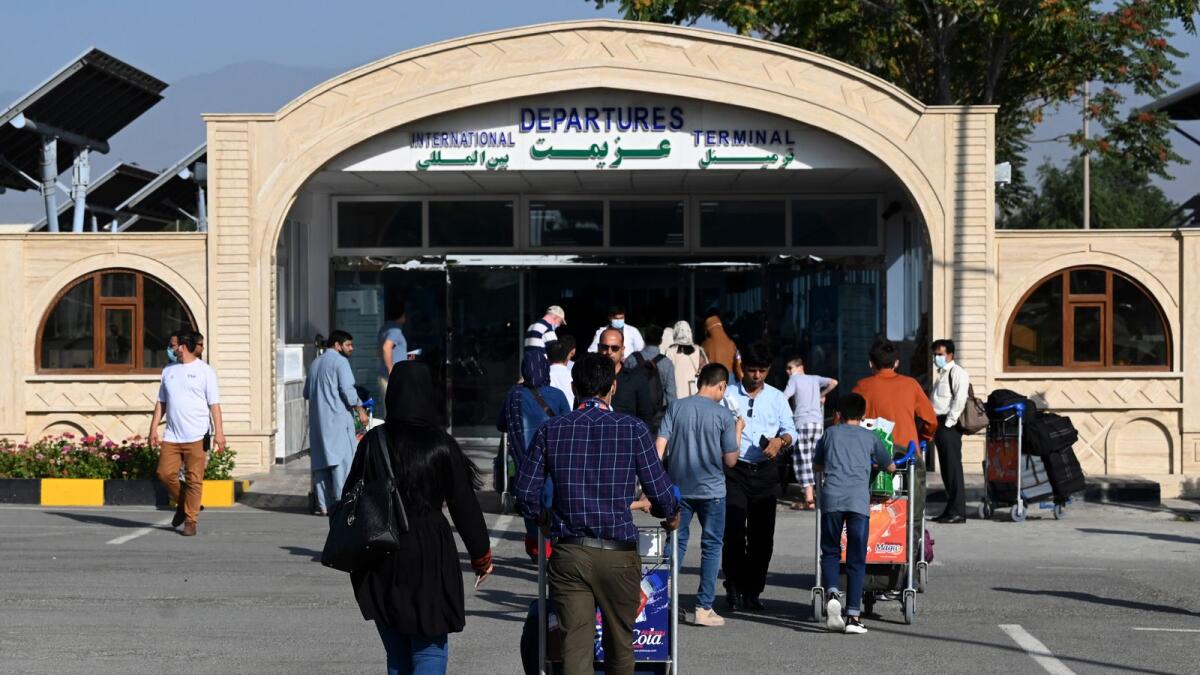 Passengers queue to enter the departures terminal of the Hamid Karzai International Airport in Kabul. Photo: AFP