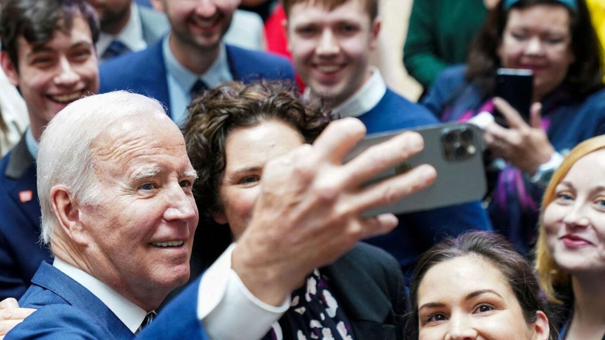 US President Joe Biden poses with students on the 25th anniversary of the Belfast/Good Friday Agreement, at Ulster University, Belfast, Northern Ireland, on Wednesday. — Reuters