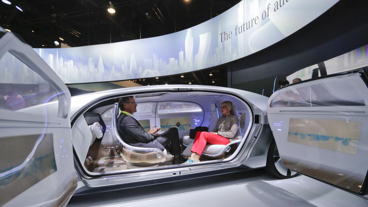 Attendees sit in the self-driving Mercedes-Benz F 015 concept car at the Mercedes-Benz booth at the International CES, in Las Vegas