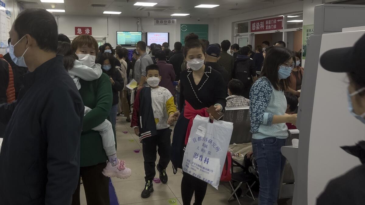 Parents with their children wait at a crowded holding room of a children's hospital in Beijing. — AP