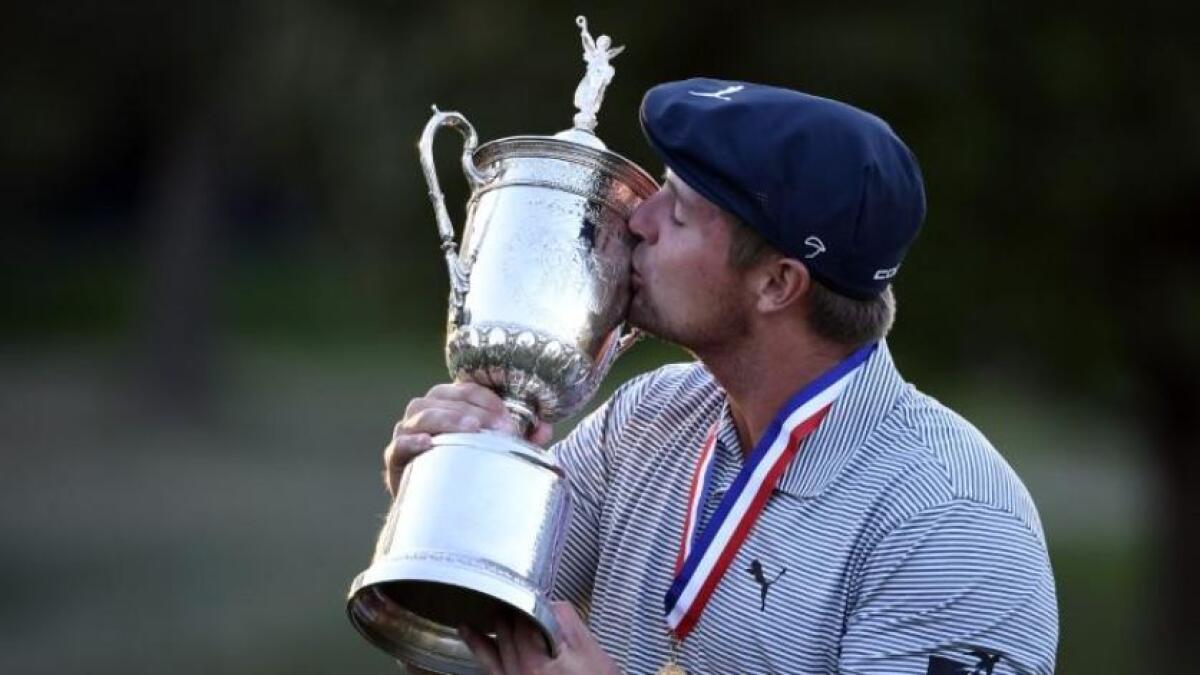 Bryson DeChambeau poses and celebrates with the trophy after winning the US Open. (Reuters)