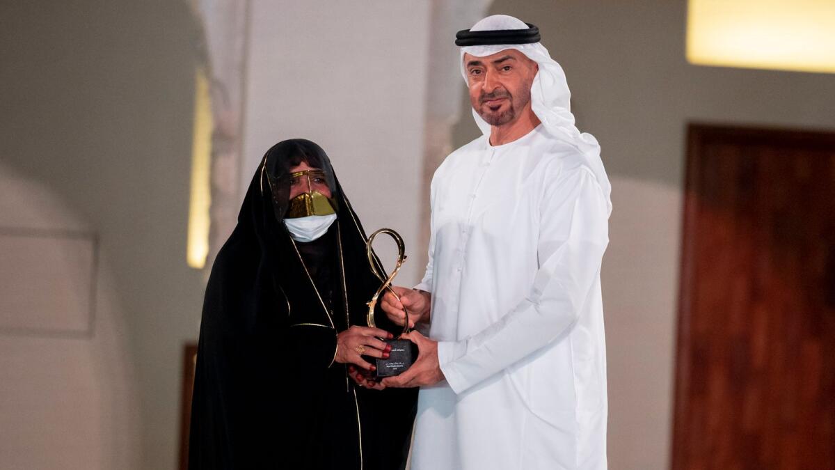 Sheikh Mohamed presents an award to Zafaranaa Ahmed Khamis.