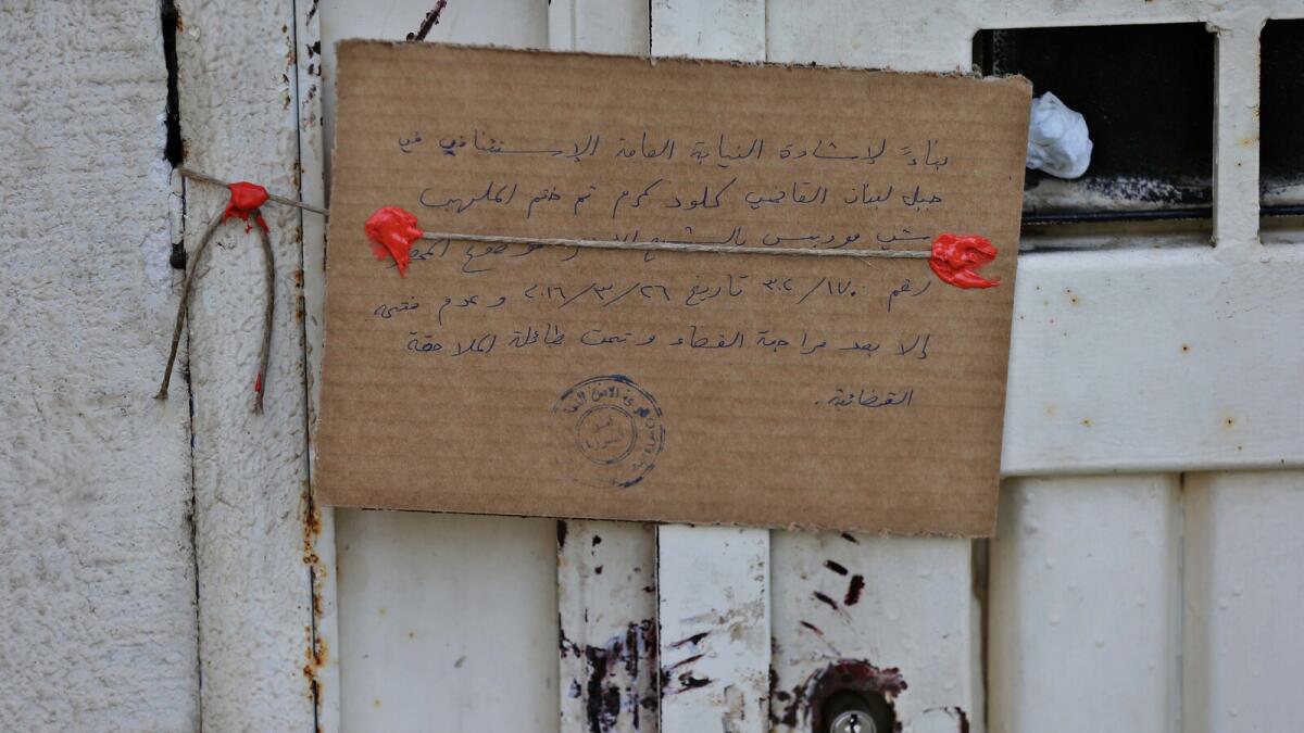 In this Thursday April 7, 2016 photo, a hand-written sign and official red wax seals hang on the main gate of the closed Chez Maurice Hotel, in Maamelteine, north of Beirut, Lebanon.