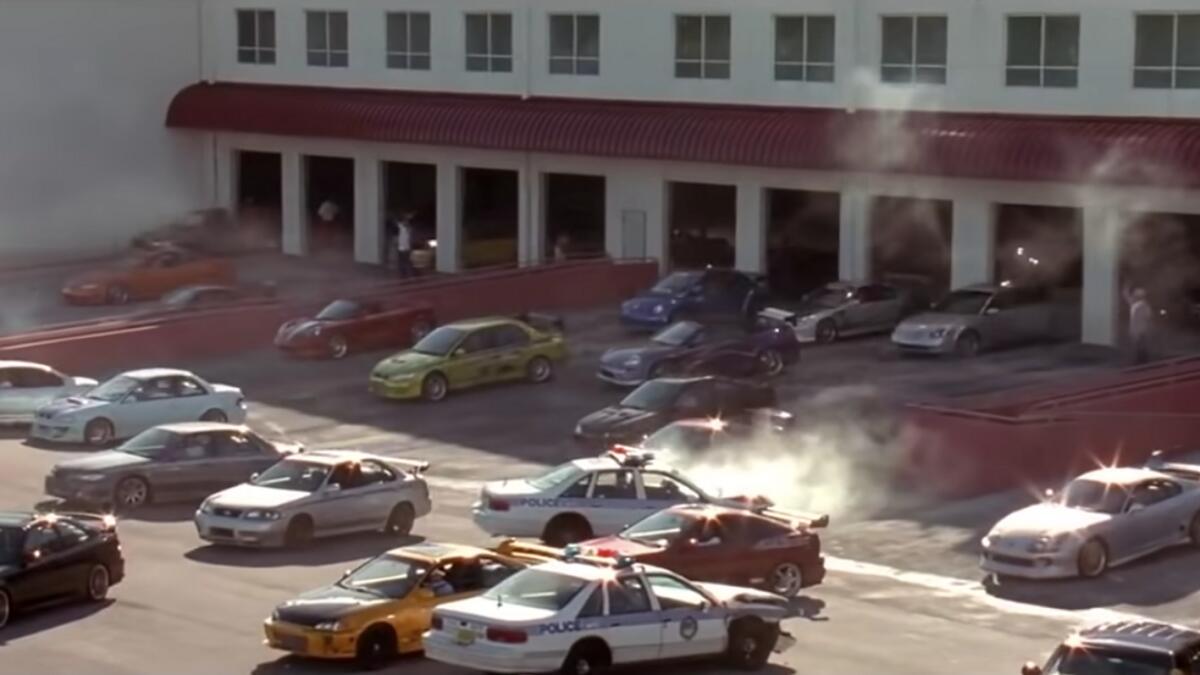3) It’s a Scramble, Baby! (2 Fast 2 Furious - 2003).  In 2 Fast 2 Furious (2003), Brian works with US customs to keep himself out of trouble after the events of the first movie. The only F&amp;F film to not feature Vin Diesel, however, it introduces other vital characters, Tyrese Gibson’s Roman Pearce, who is Brian’s childhood friend and Tej Parker, played by Ludacris. The film featured one of the best escape scenes of all time when Brian and Roman, still undercover, escape the local cops of Miami in the most F&amp;F way possible: a crazy warehouse scramble scene. How? Pockets ain’t empty, cuz!