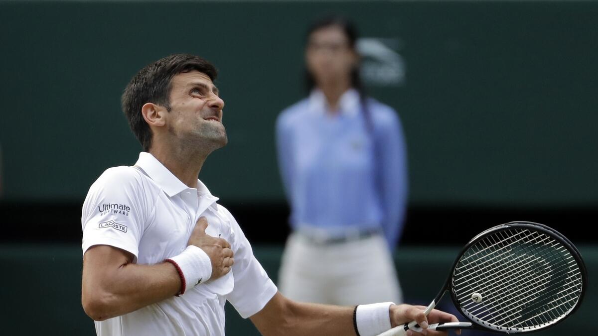 Novak Djokovic celebrates defeating Switzerland's Roger Federer in the men's singles final match of the Wimbledon Tennis Championships in London.