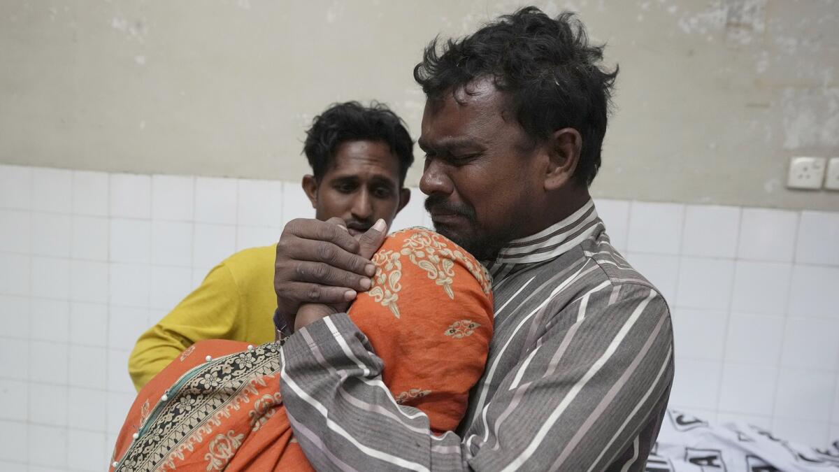 A family mourns next to the body of their family member, who was died in the stampede, at a morgue in Karachi, Pakistan, on Friday. — AP
